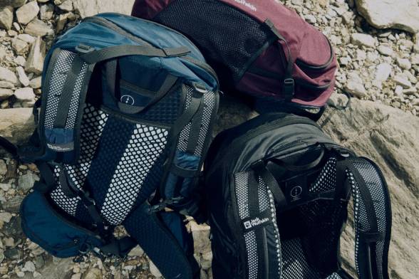 Photo of three hiking packs on rocky ground