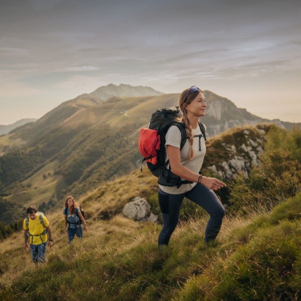 Three people in spring hiking outfits in a mountainous region.