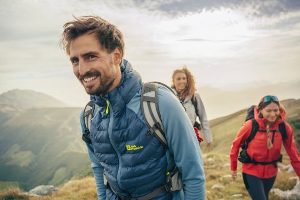 Man and two women in hiking outfits in a mountainous region
