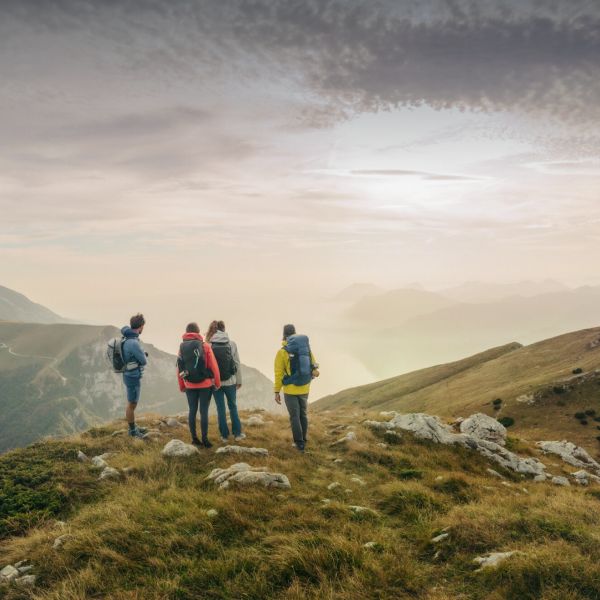 Rear view of four hikers in a mountainous region in spring